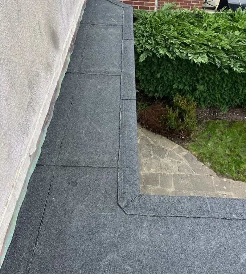 Close detail of a newly bonded flat roof membrane corner and trim