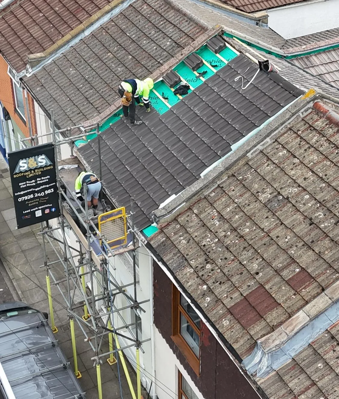 Roof eaves with new battens and breathable felt exposed during roofing work