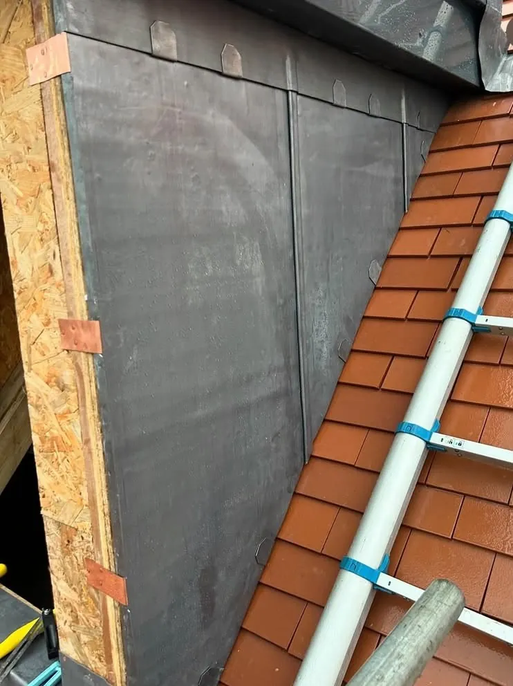 Close view of hand-dressed lead side cladding on a dormer cheek